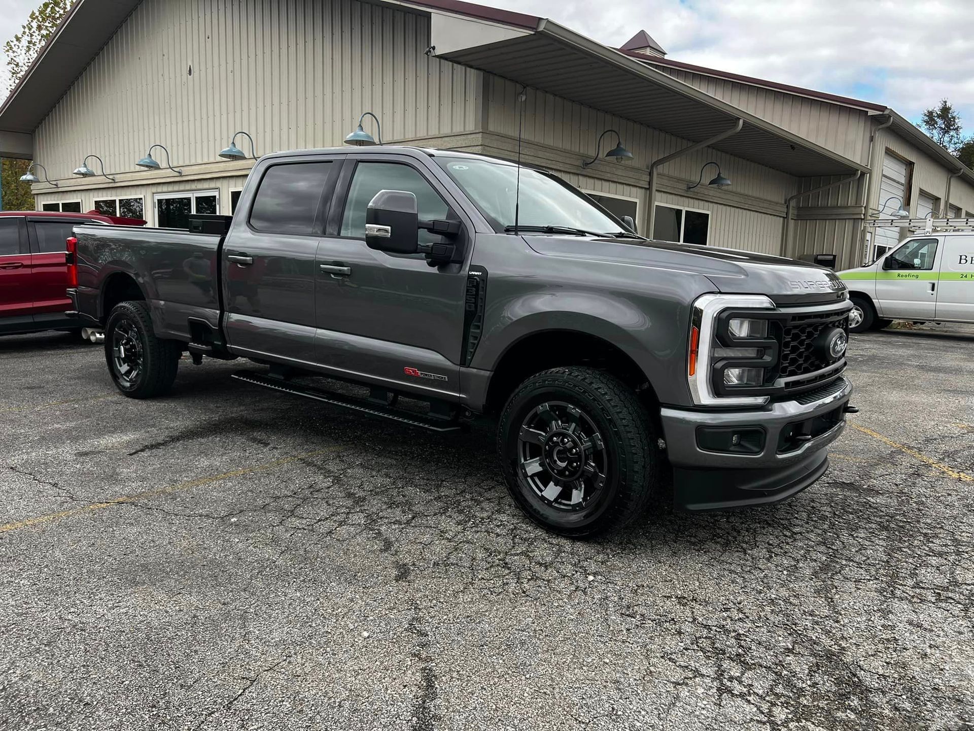 A white lamborghini with its doors open is parked in a garage.