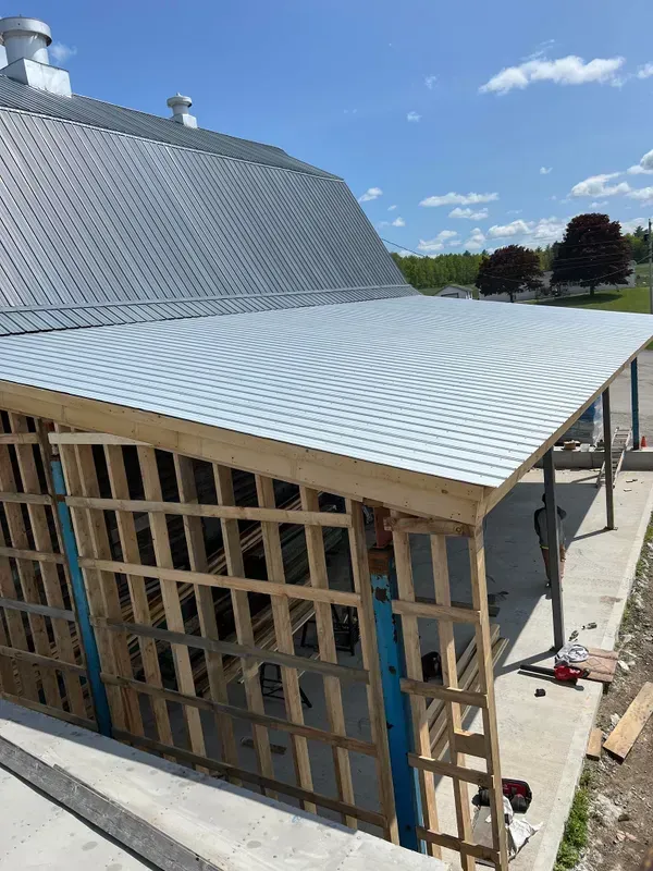 A metal roof is being installed on a building under construction.