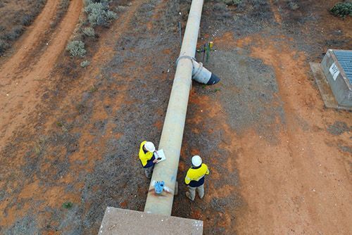 An aerial view of two men working on a large pipe — Water Filtration Systems in Mackay, QLD