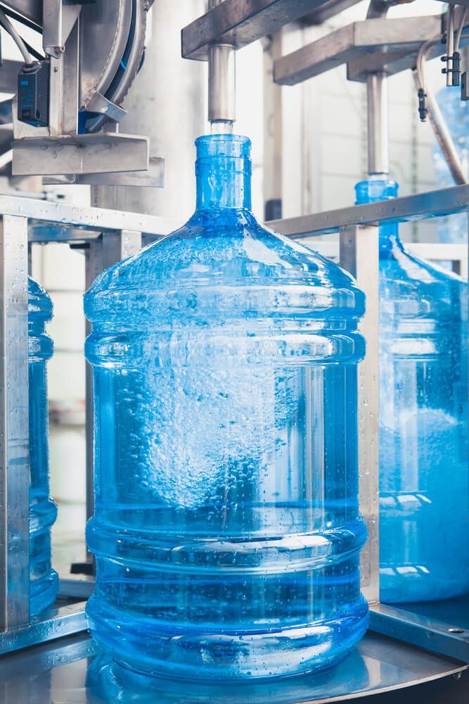 Large blue bottle is being filled with water  — Water Filtration Systems in Mackay, QLD