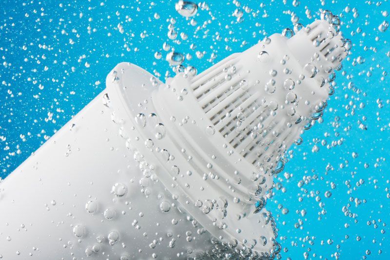 A Water Filter Is Floating In The Water With Bubbles Coming Out Of It — Eureka Water & Filtration In Mount St John, QLD