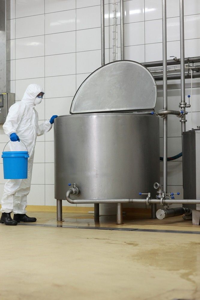 Man in a protective suit is holding a blue bucket — Water Filtration Systems in Cairns, QLD