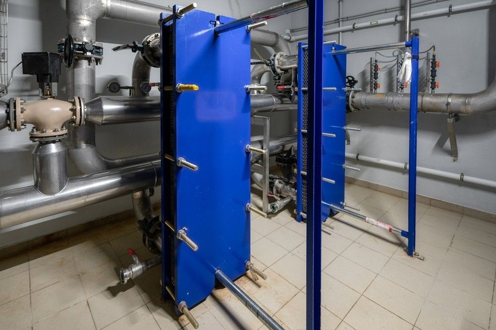 Room with a lot of pipes and blue panels— Water Filtration Systems in Mount Isa, QLD