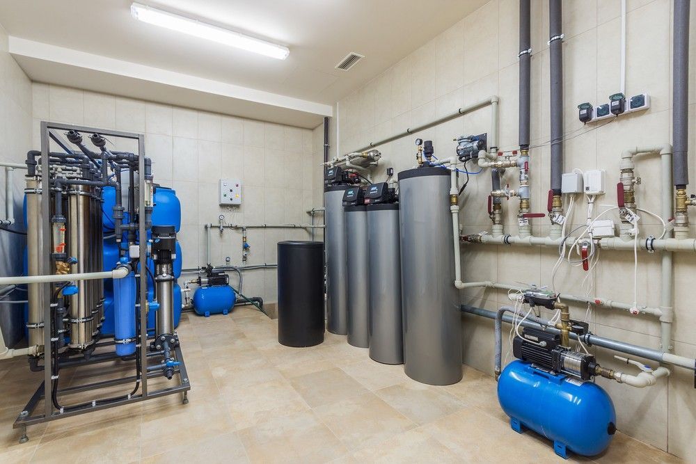 Room with a lot of pipes and a blue tank — Water Filtration Systems in Cairns, QLD