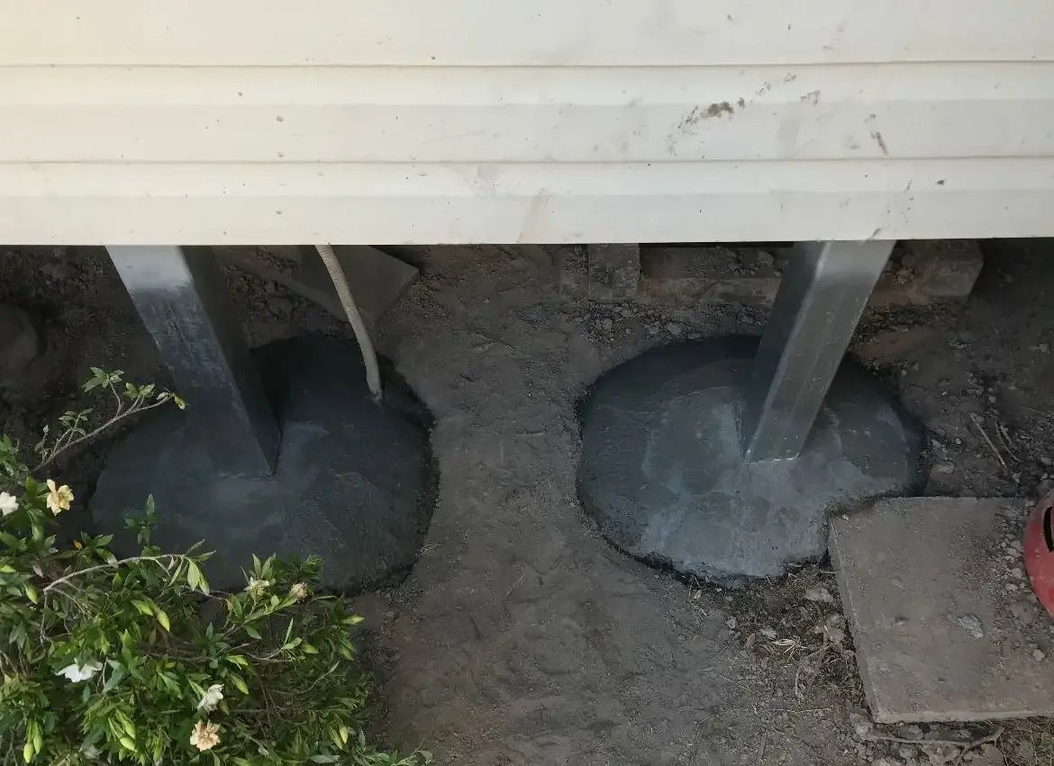 Yellow House With a Blue Roof is Sitting on Top of a Hill — Wilson's House Restumping in Tweed Heads, NSW