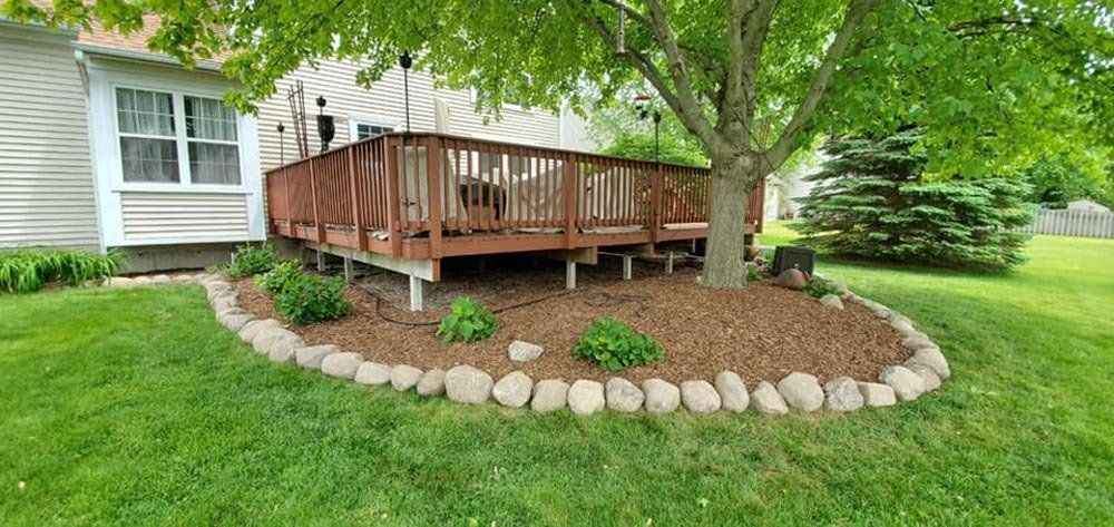 A white house with a large bush in front of it. shrub trim 