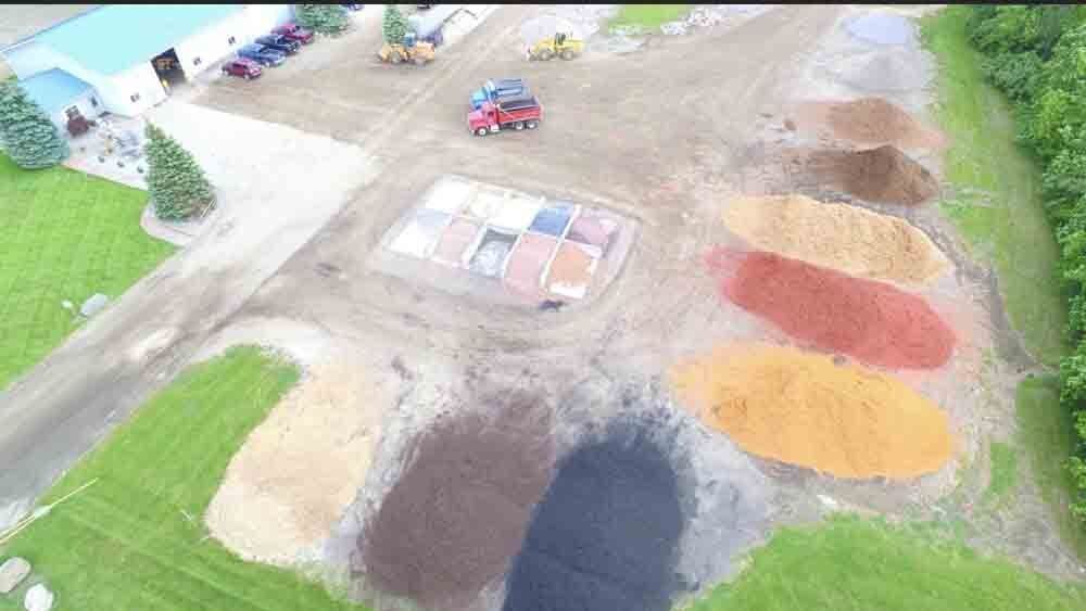 A brick house with a black mulch bed in front of it. mulch installation.