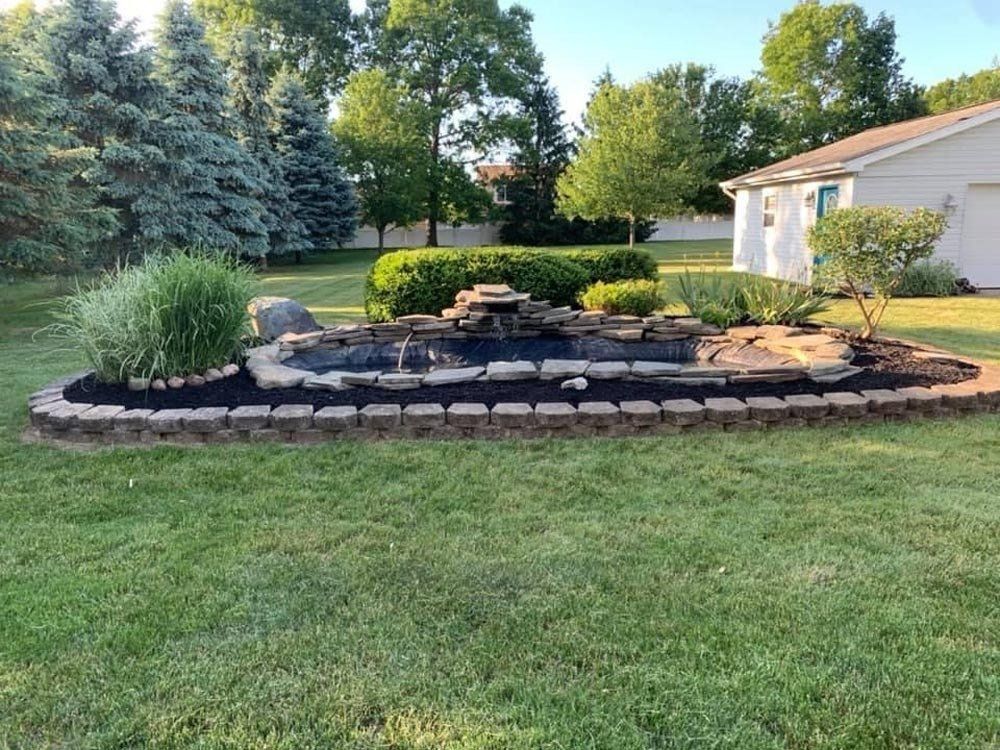 There is a rainbow in the sky in front of a house. retaining wall