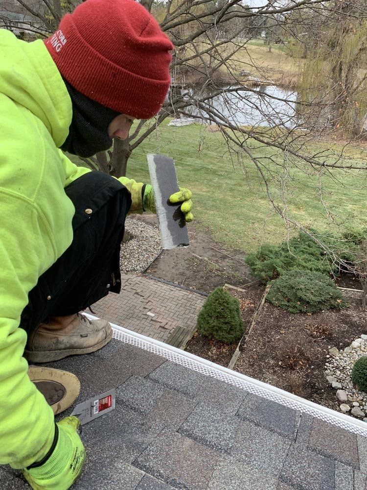 A man in a hat is giving a thumbs up in front of a dumpster trailer. junk removal
