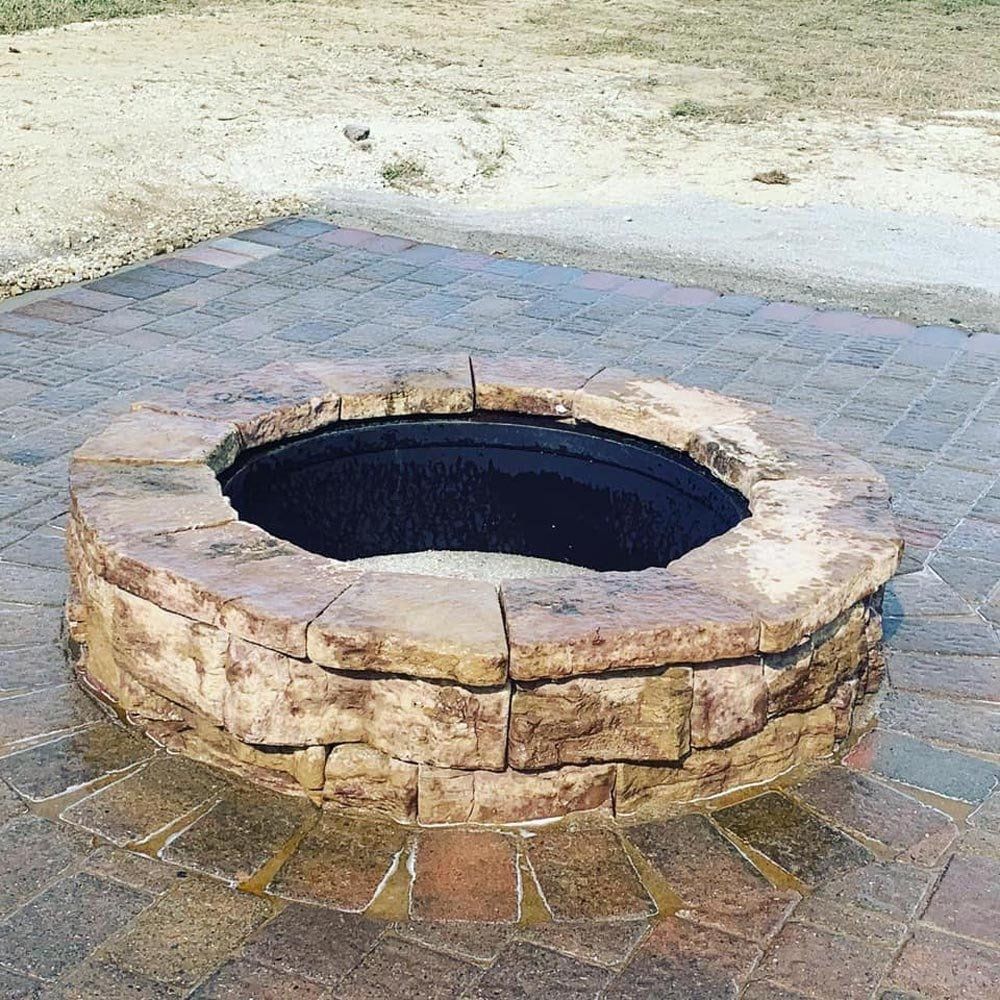 A white house with a brick wall in front of it. retaining wall