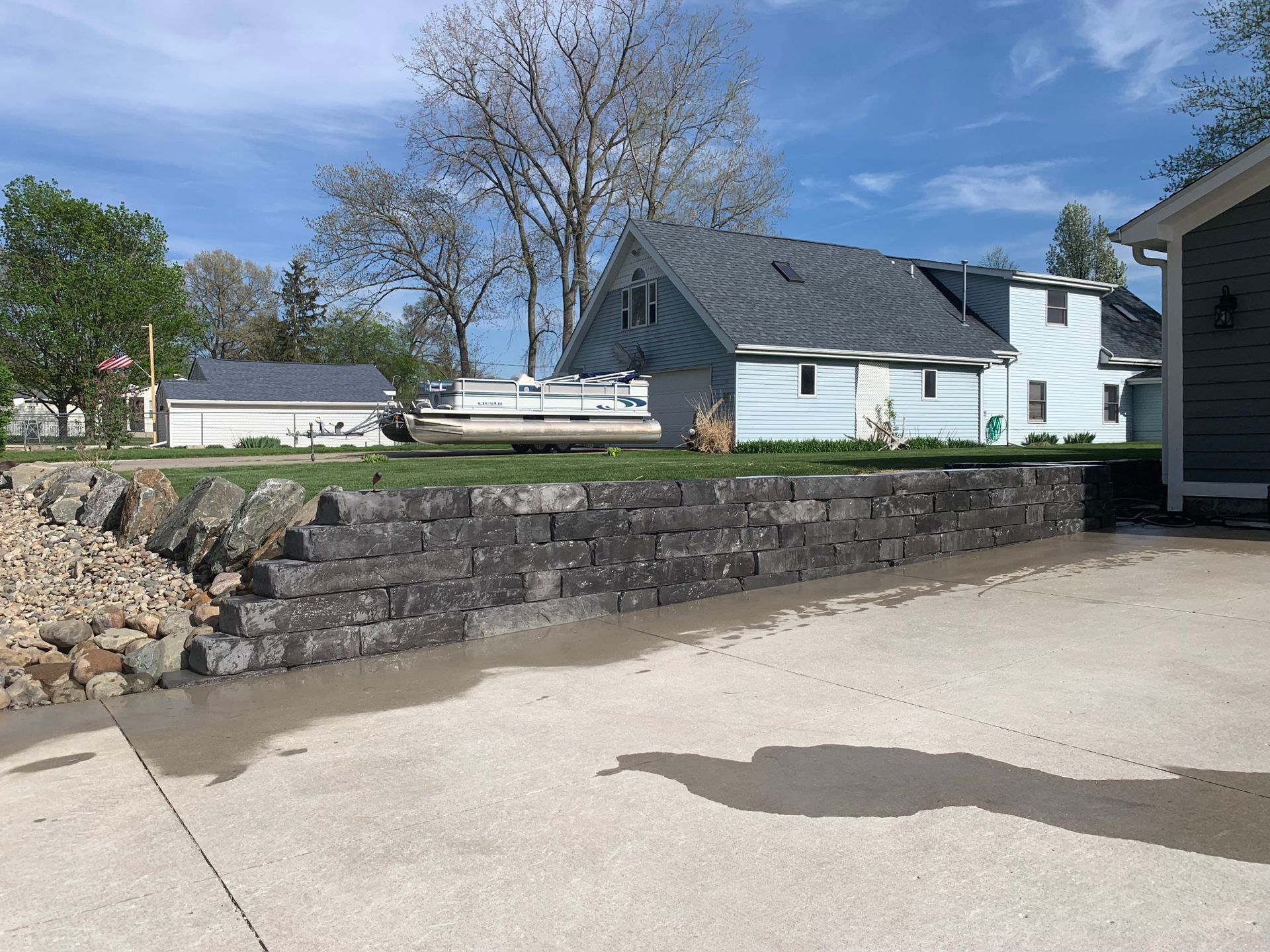 A patio with stairs and a chair in front of a house with a sliding glass door. brick pavers