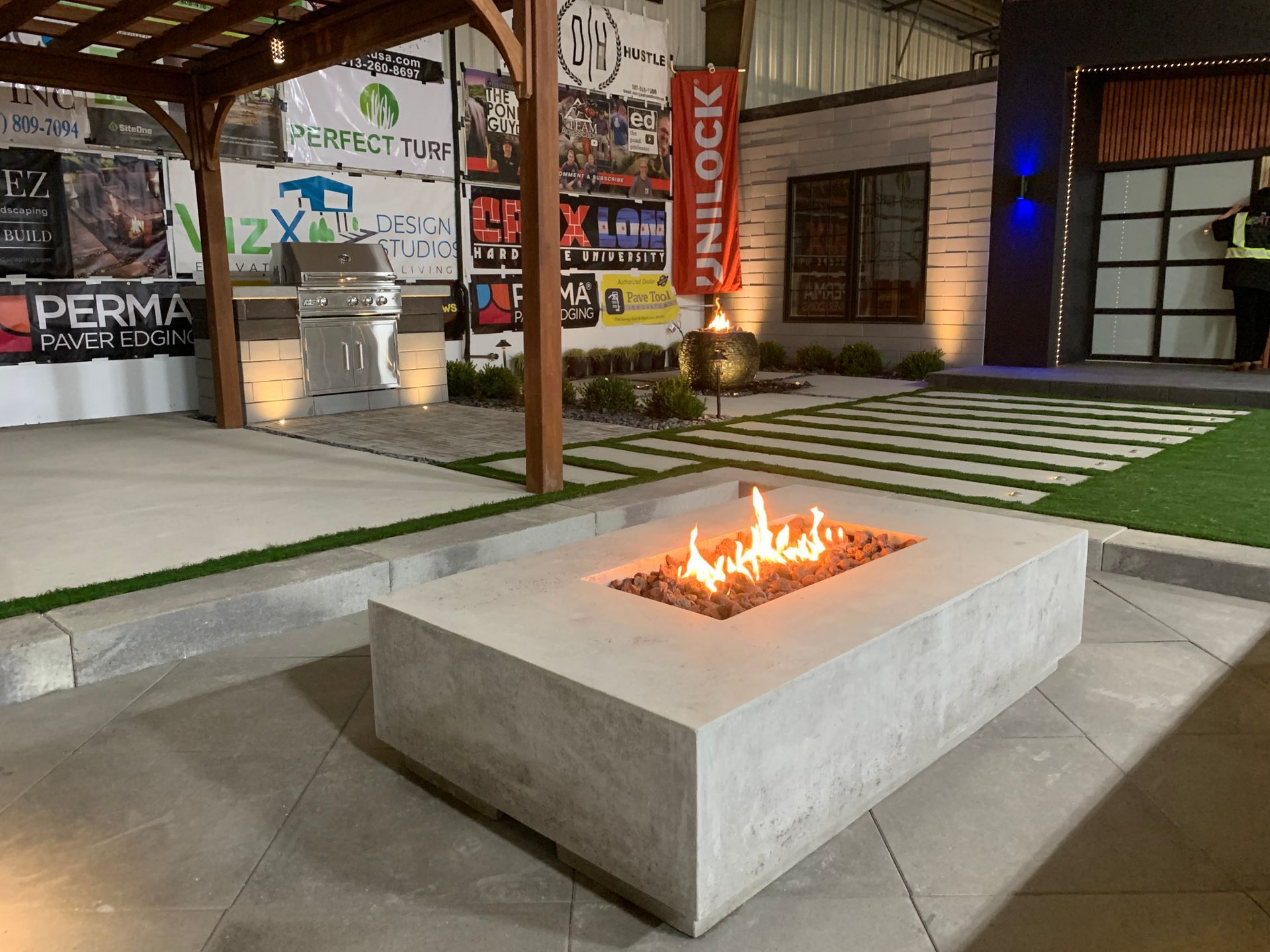 A fire pit is sitting in front of a building. fire feature. gas.