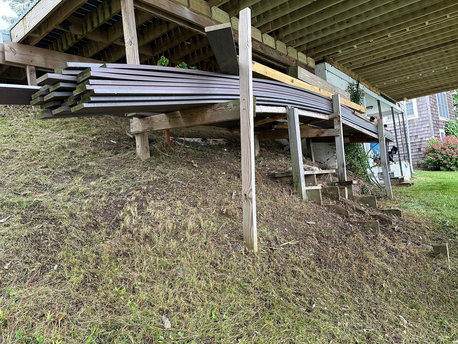 a wooden deck is sitting on top of a grassy hill .