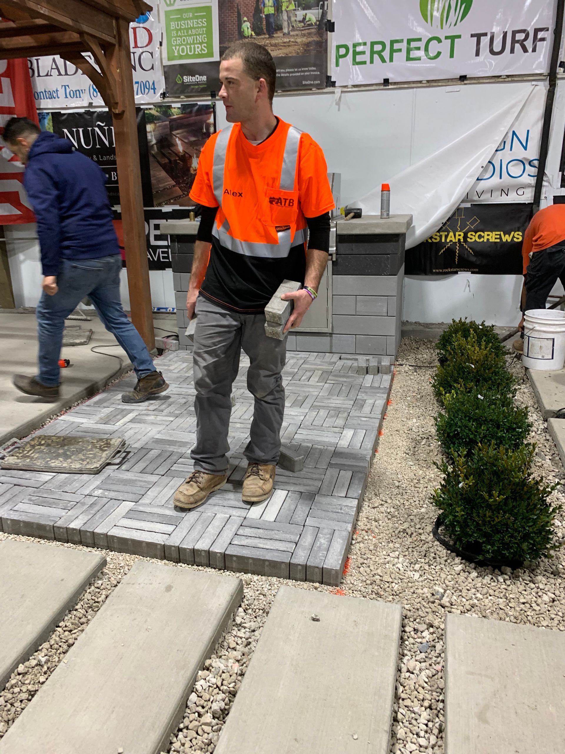A man is standing in front of a perfect turf sign