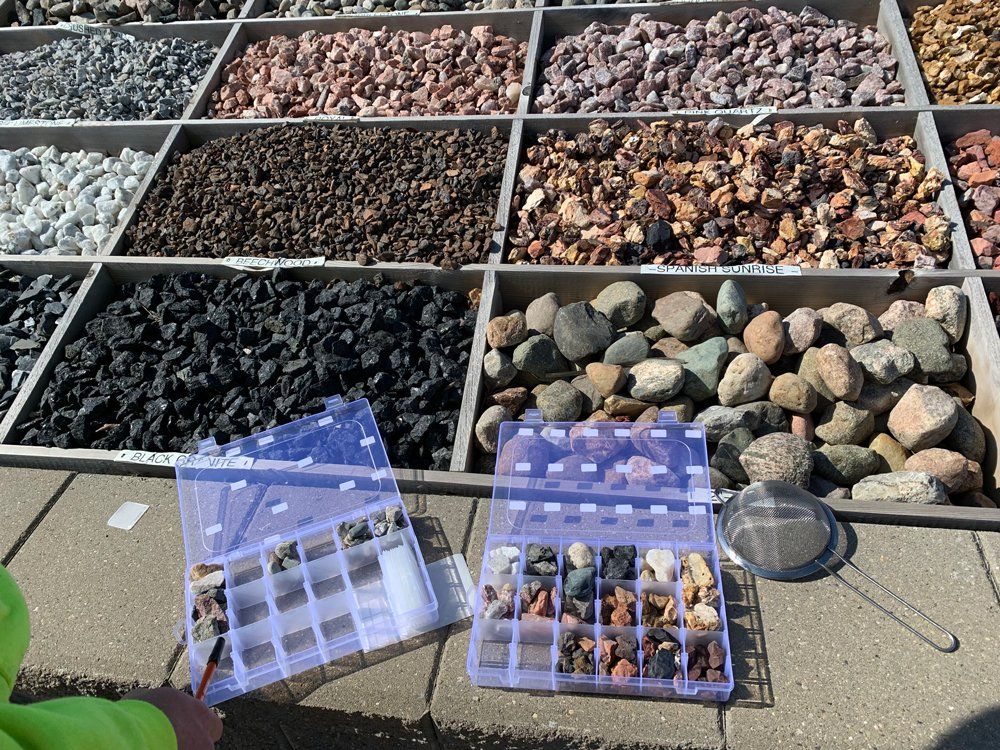 A brick wall with a bunch of rocks on it and a windmill in the background. rock installation