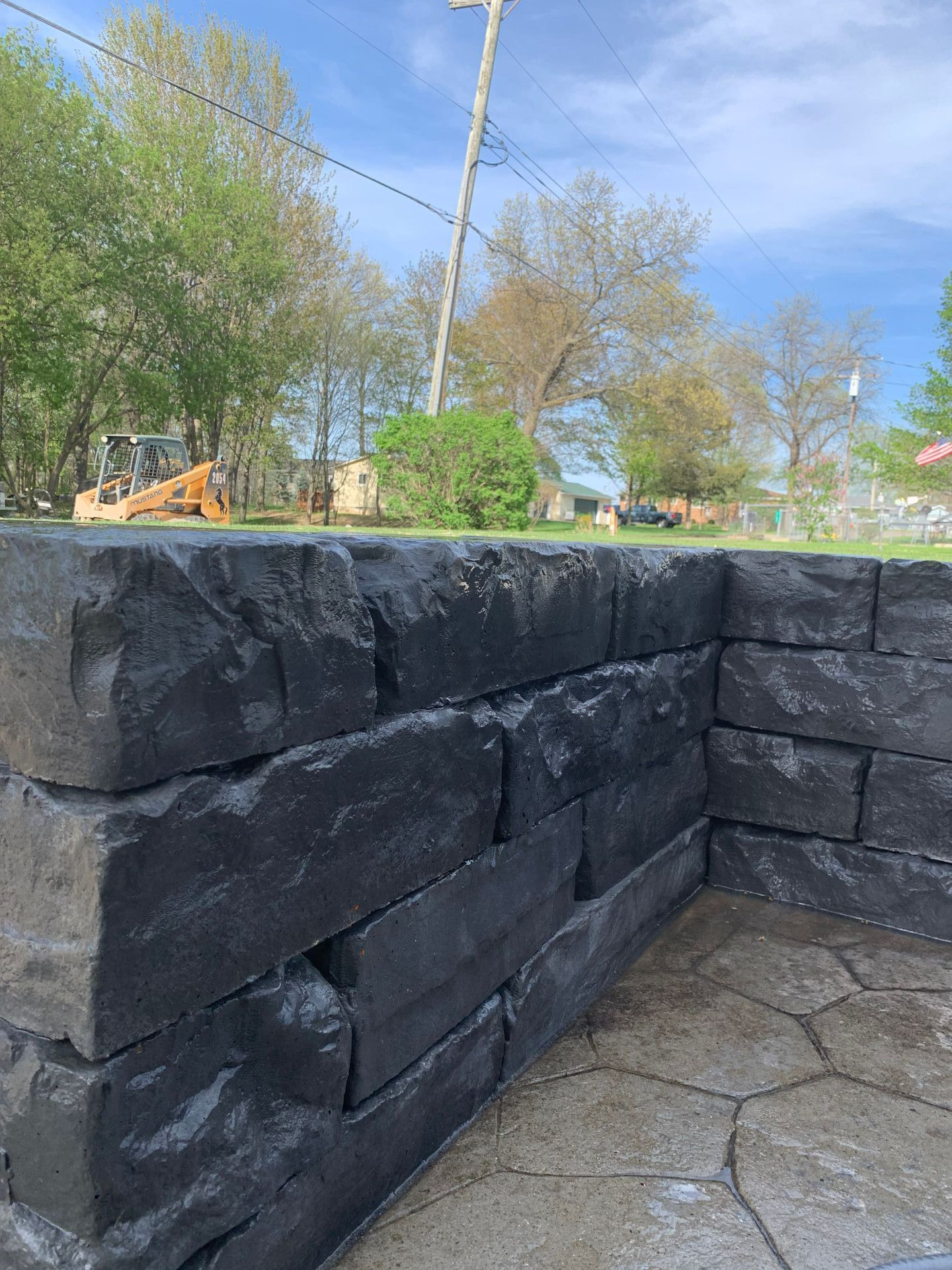 A house with a boat parked in front of it. retaining wall