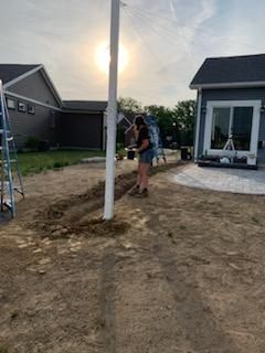 A man wearing a hat and a shirt that says clpa is giving a thumbs up. landscape lighting.