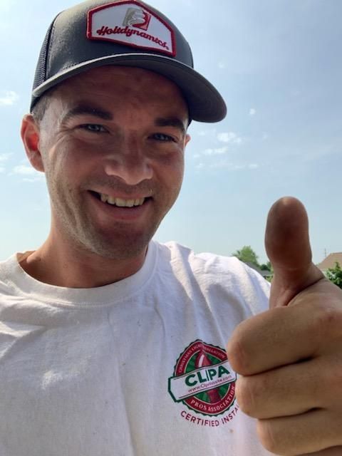 A man and woman are kneeling in the dirt in front of a house. landscape lighting
