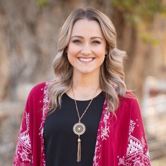 The woman is wearing a scarf and smiling for the camera.