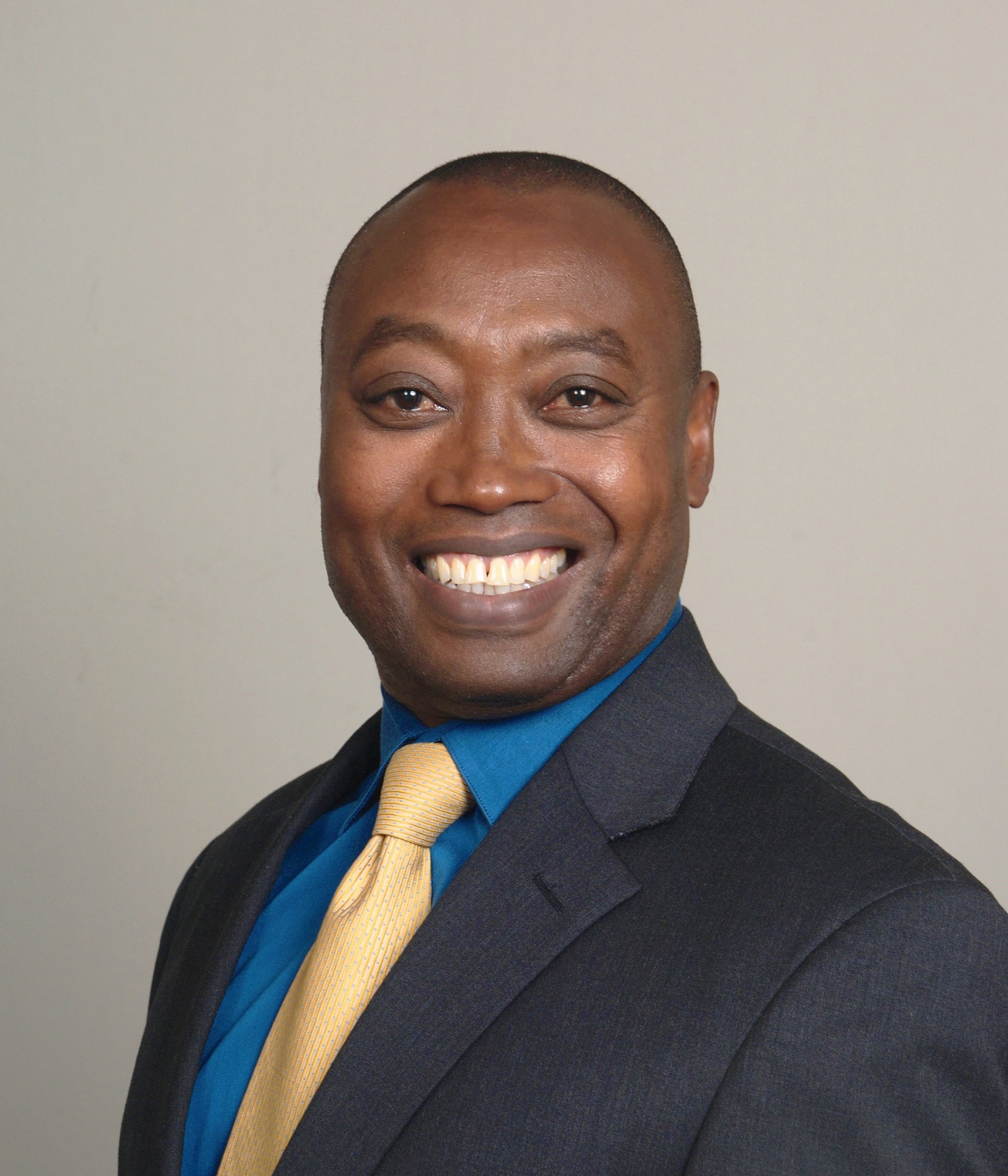 A man in a suit and tie is smiling for the camera