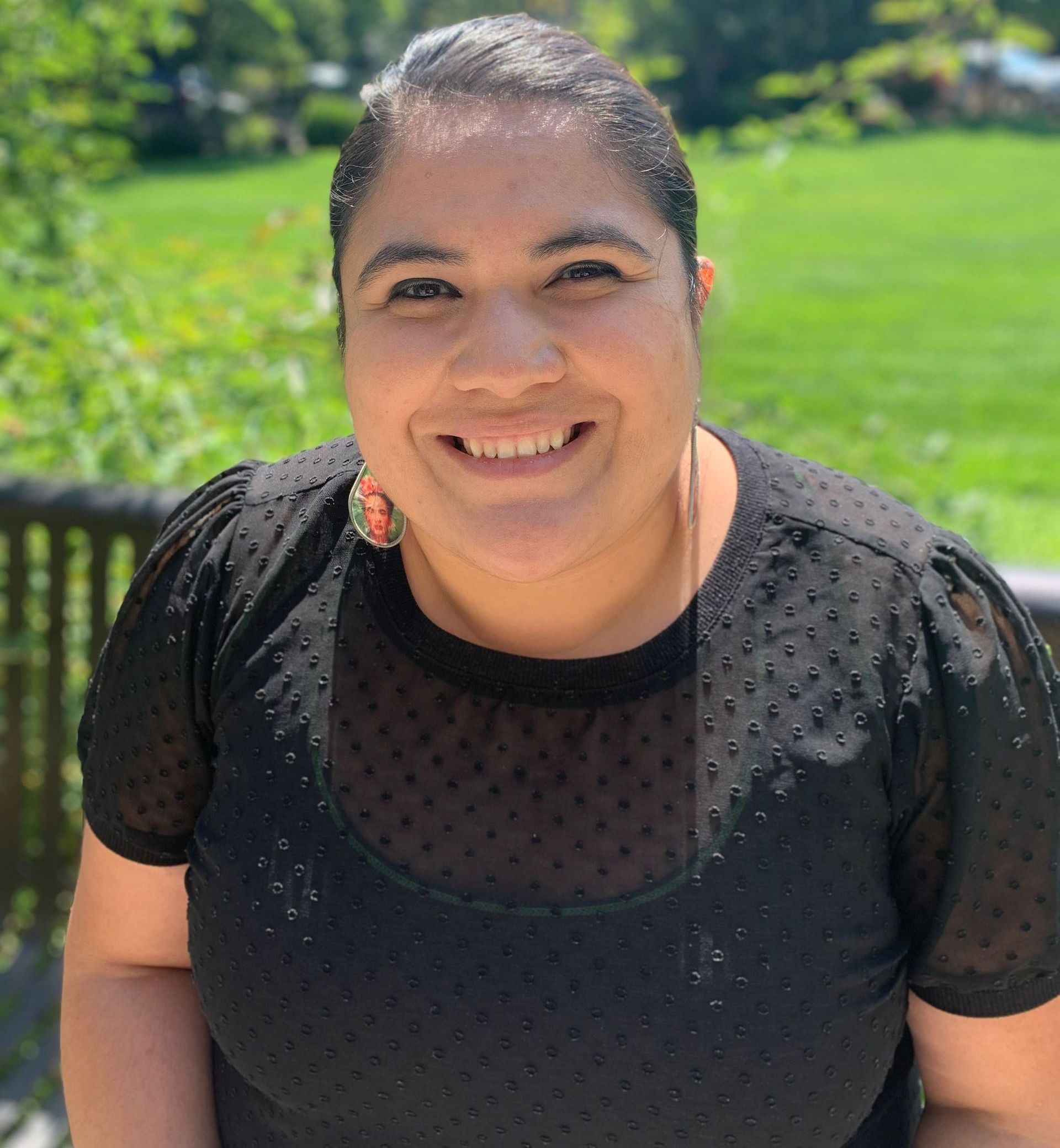 A woman in a black shirt is smiling for the camera