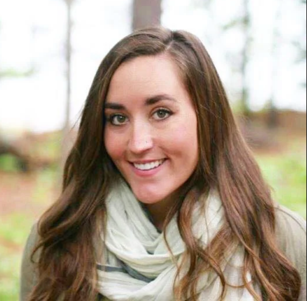 The woman is wearing a scarf and smiling for the camera.