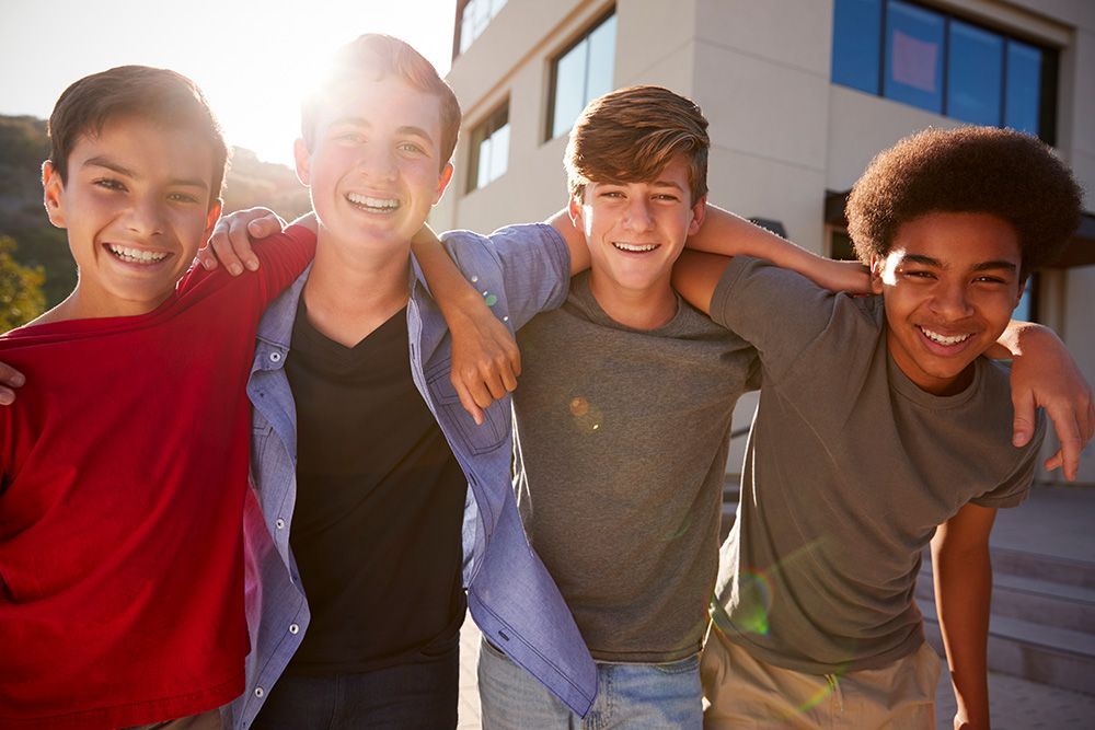 A group of young men are posing for a picture in front of a building.
