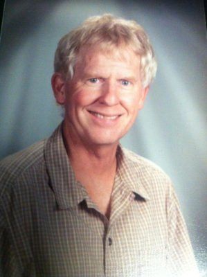 A man in a plaid shirt is smiling for the camera.