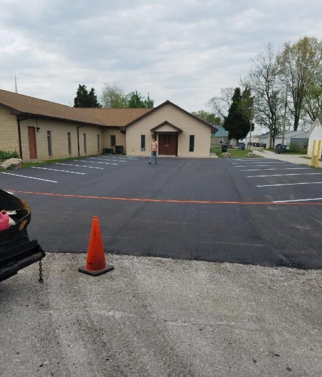 A parking lot with an orange cone in front of a building