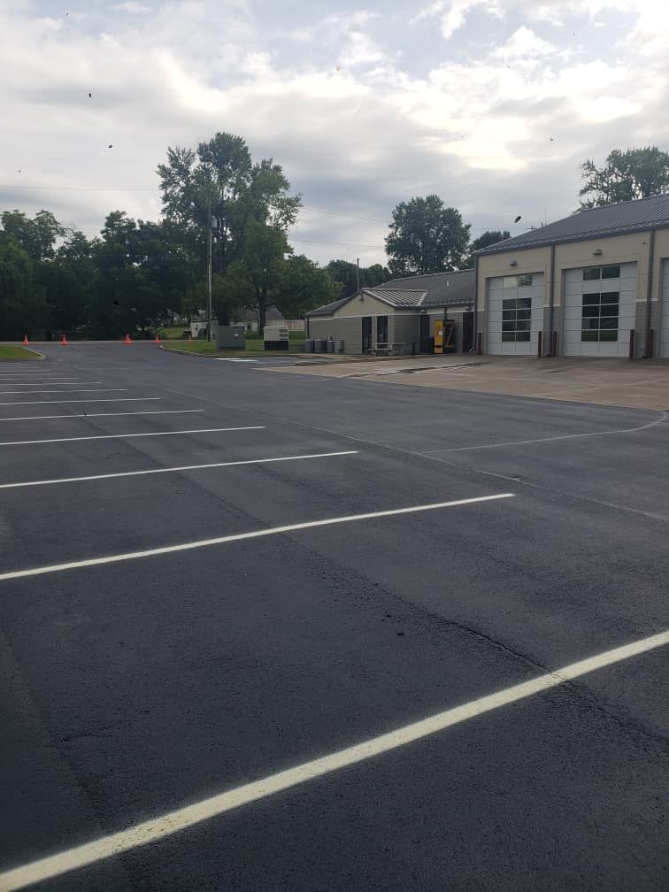 An empty parking lot with a building in the background