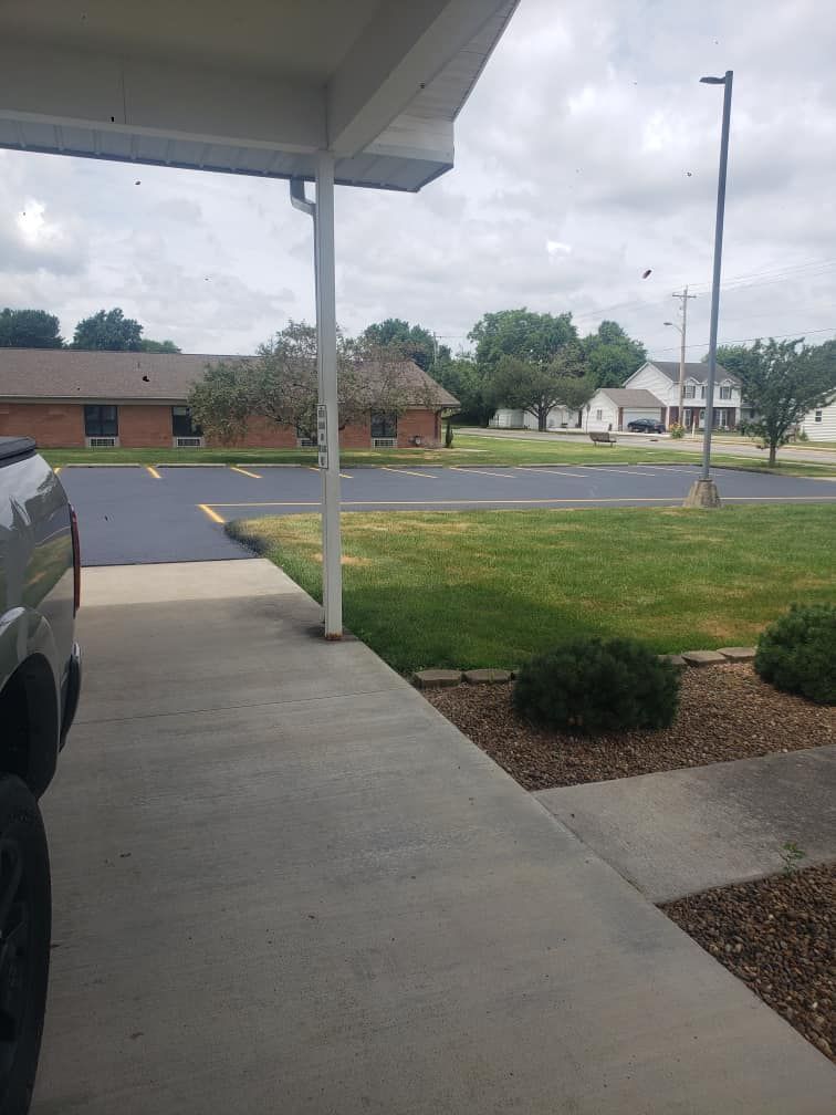 A truck is parked under a canopy in a parking lot.