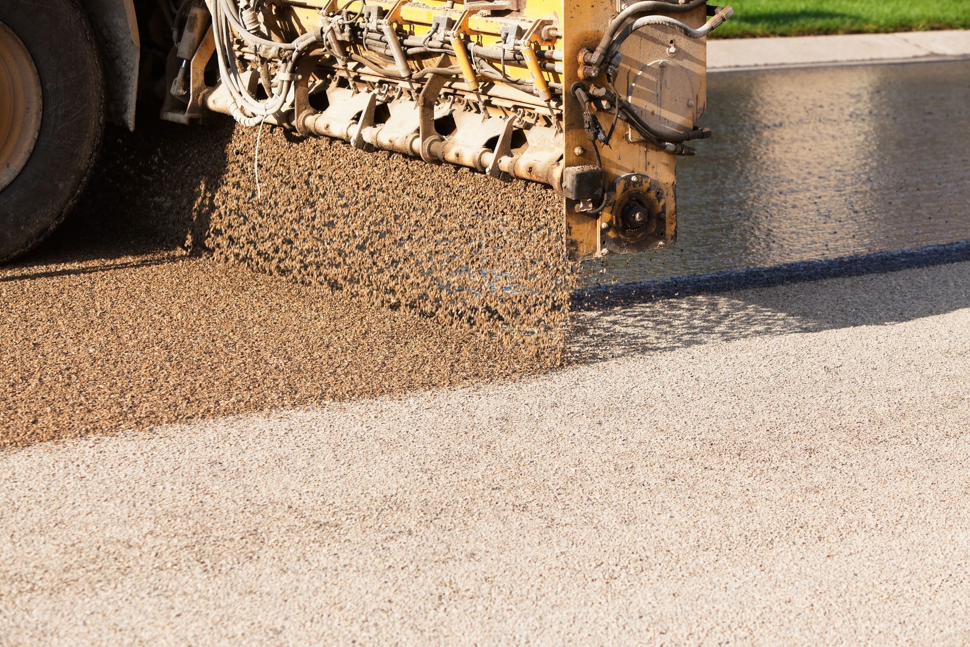 A truck is laying asphalt on a road.
