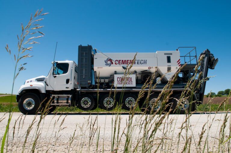 A cement truck is parked on the side of the road
