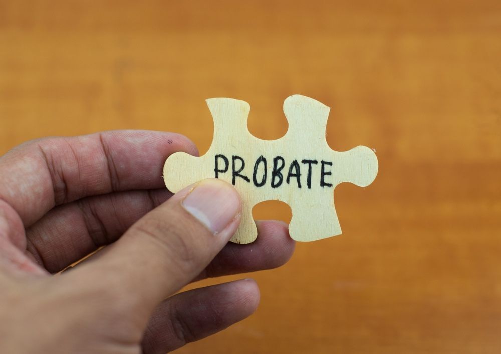 A Person is Holding a Piece of Puzzle With the Word Probate Written on It — Paton Hooke Lawyers & Conveyancers In Taree, NSW