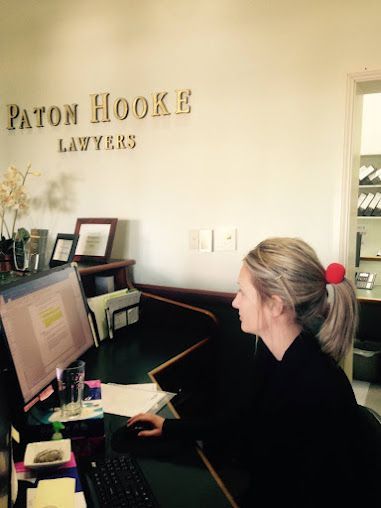 A Woman Sits at a Desk With a Computer — Paton Hooke Lawyers & Conveyancers In Old Bar, NSW