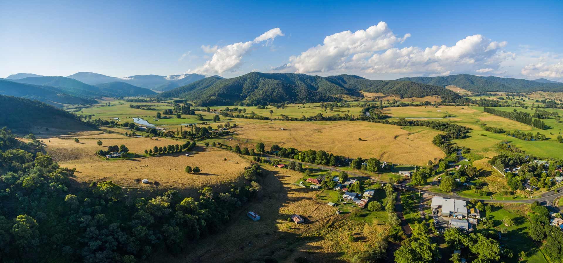 An Aerial View of a Lush Green Valley With Mountains in the Background — Paton Hooke Lawyers & Conveyancers In Taree, NSW