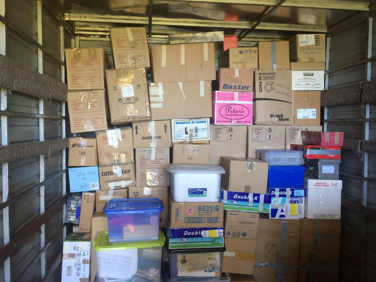 A bunch of boxes are stacked on top of each other including one that says ' busch ' on it