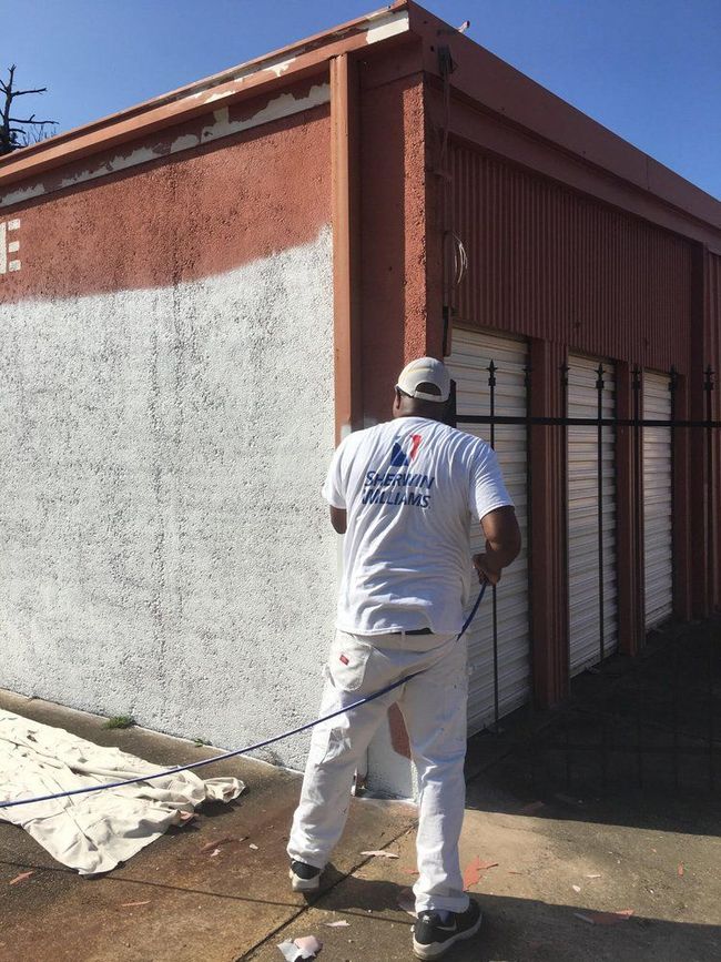 A man is painting the side of a building.