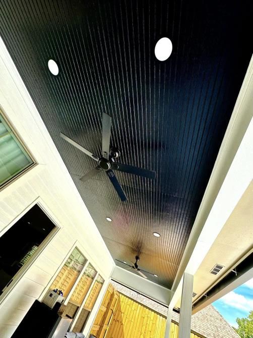 a man on a ladder fixing a ceiling fan