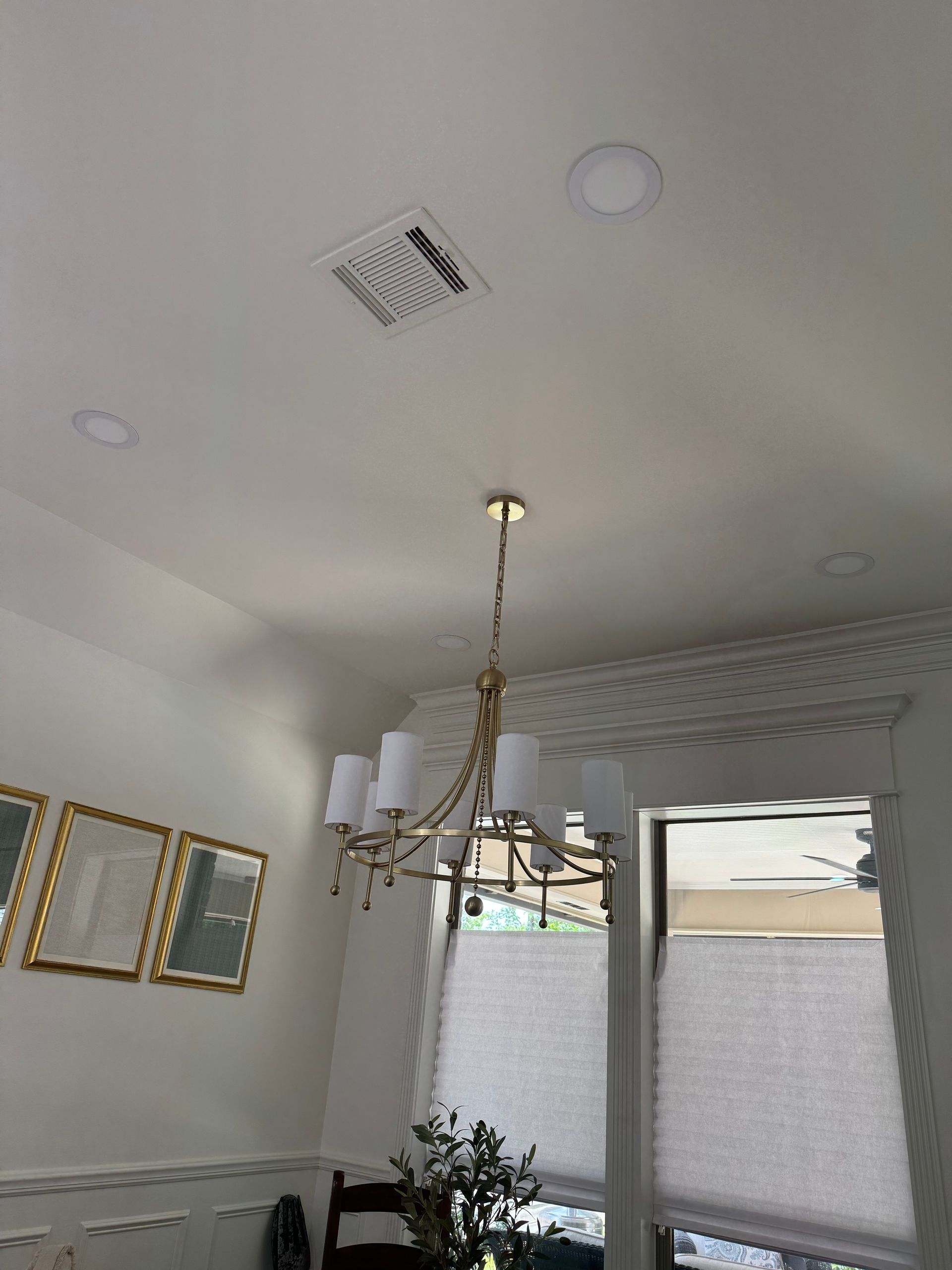 a man on a ladder fixing a ceiling fan