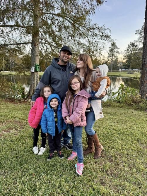 A man is installing an electrical outlet on a wall with a drill.
