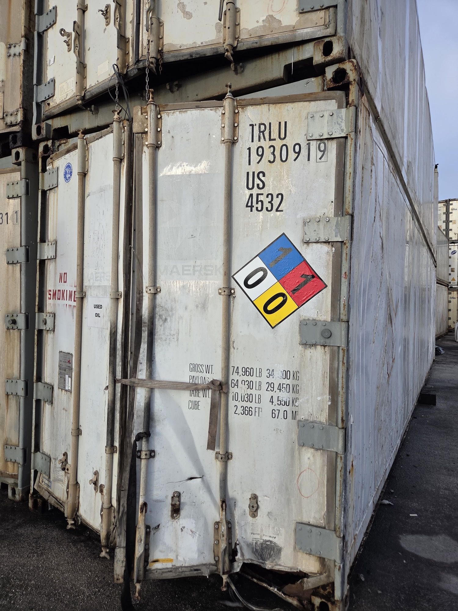 Stacked shipping containers with a hazard sign displaying 00. White, gray, and blue colors.