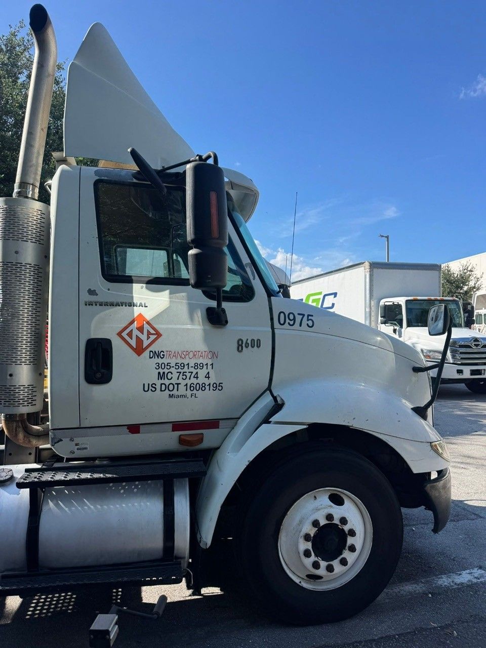 White International semi-truck parked outside; blue sky.