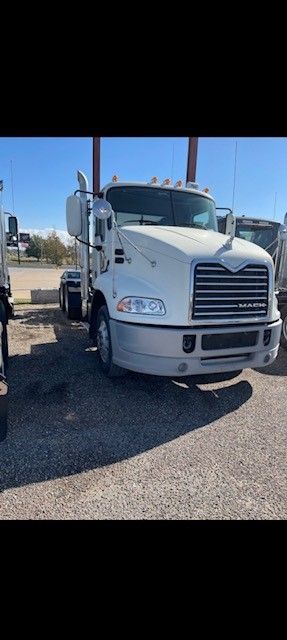 White Mack truck parked outside on a sunny day.