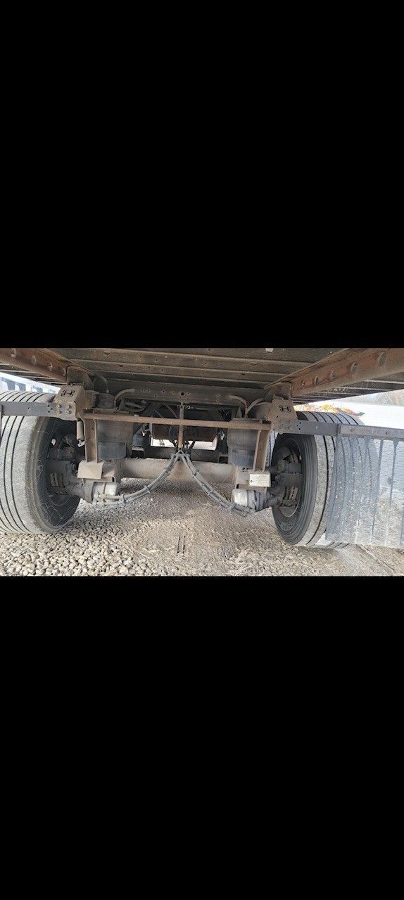 Undercarriage of a vehicle with two tires, frame, and suspension system.