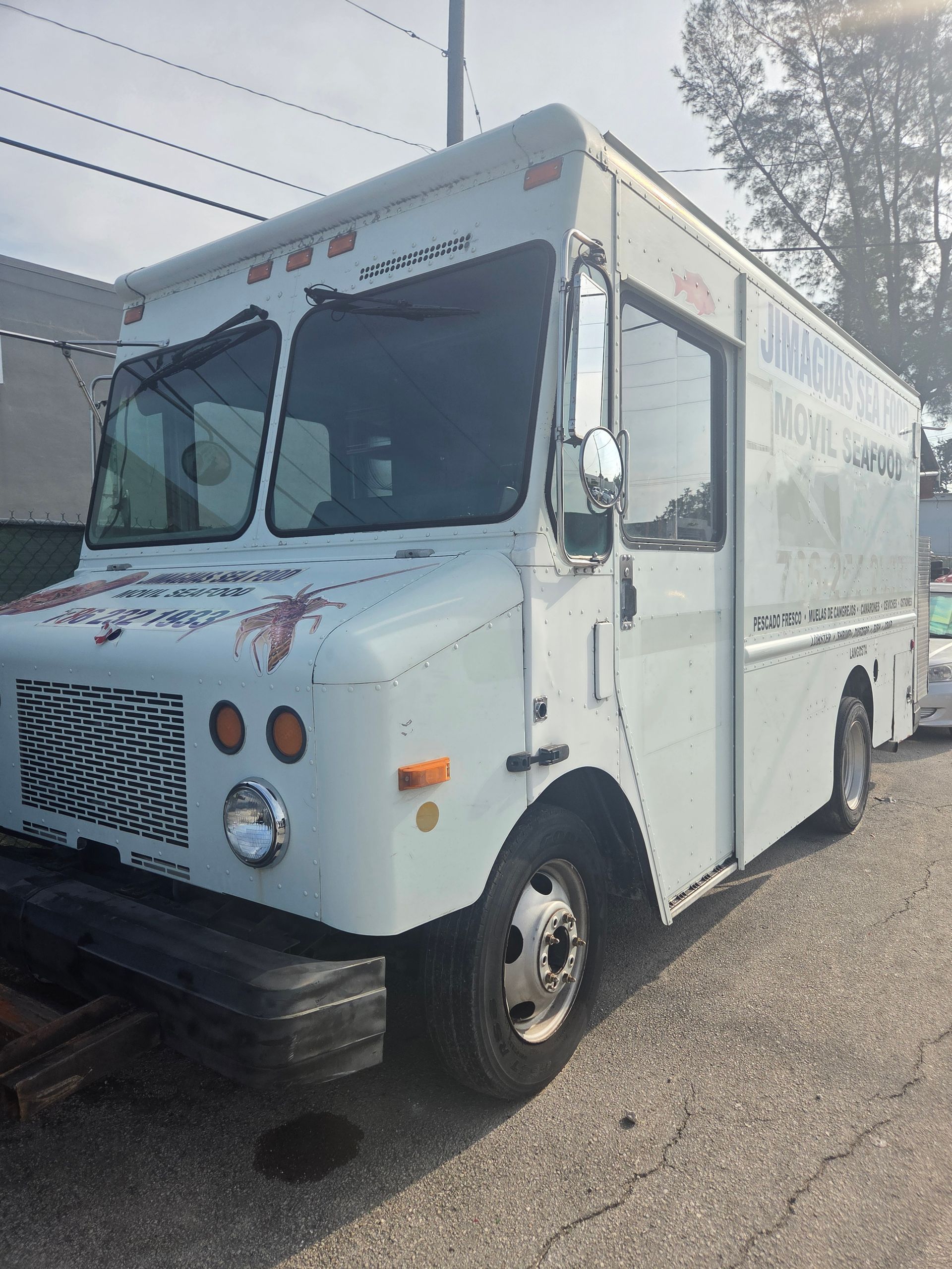 White delivery truck parked outside with red lettering.