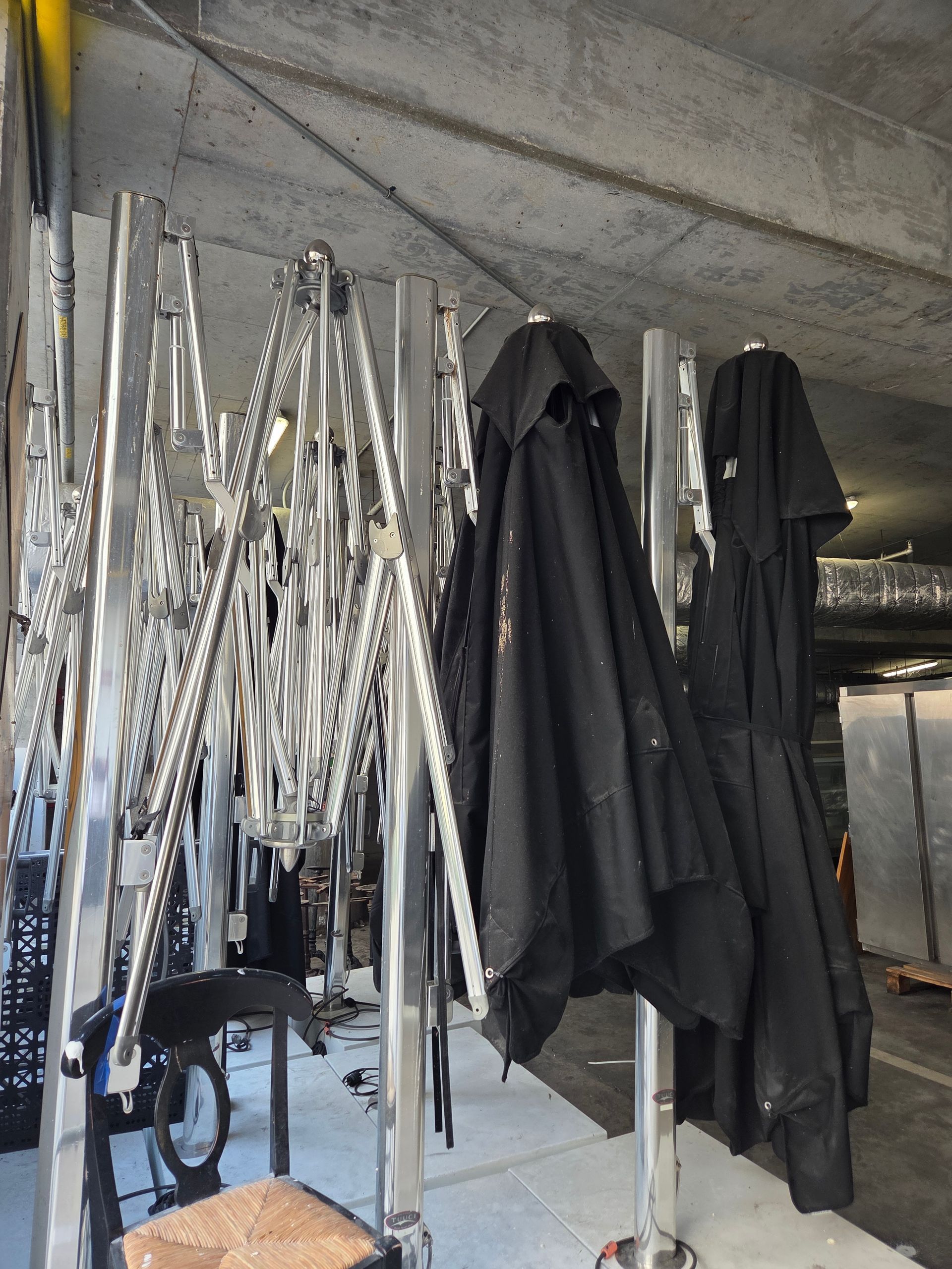 Metal clothing racks with black jackets hanging on them.
