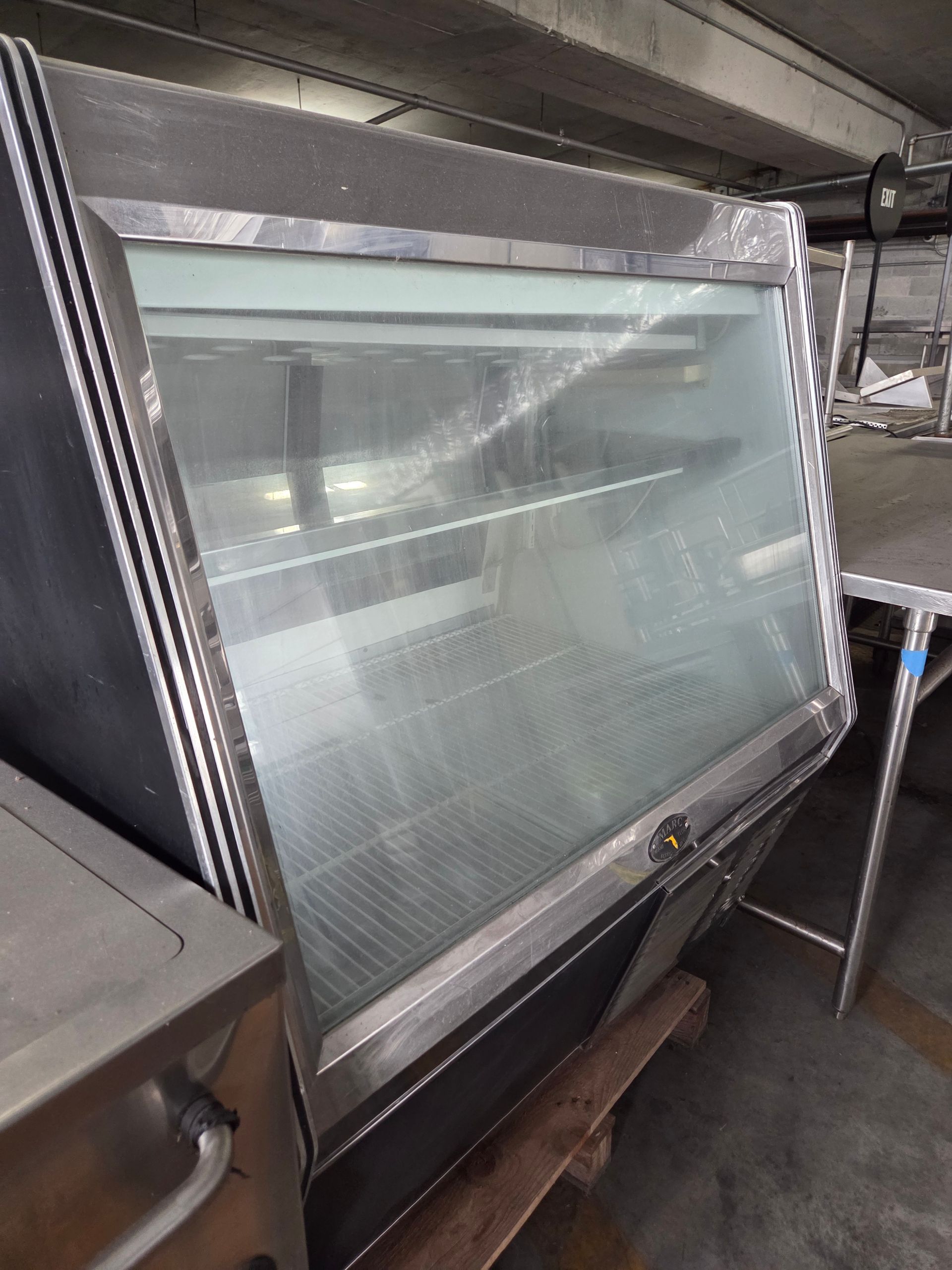 Stainless steel food display case with angled glass front.