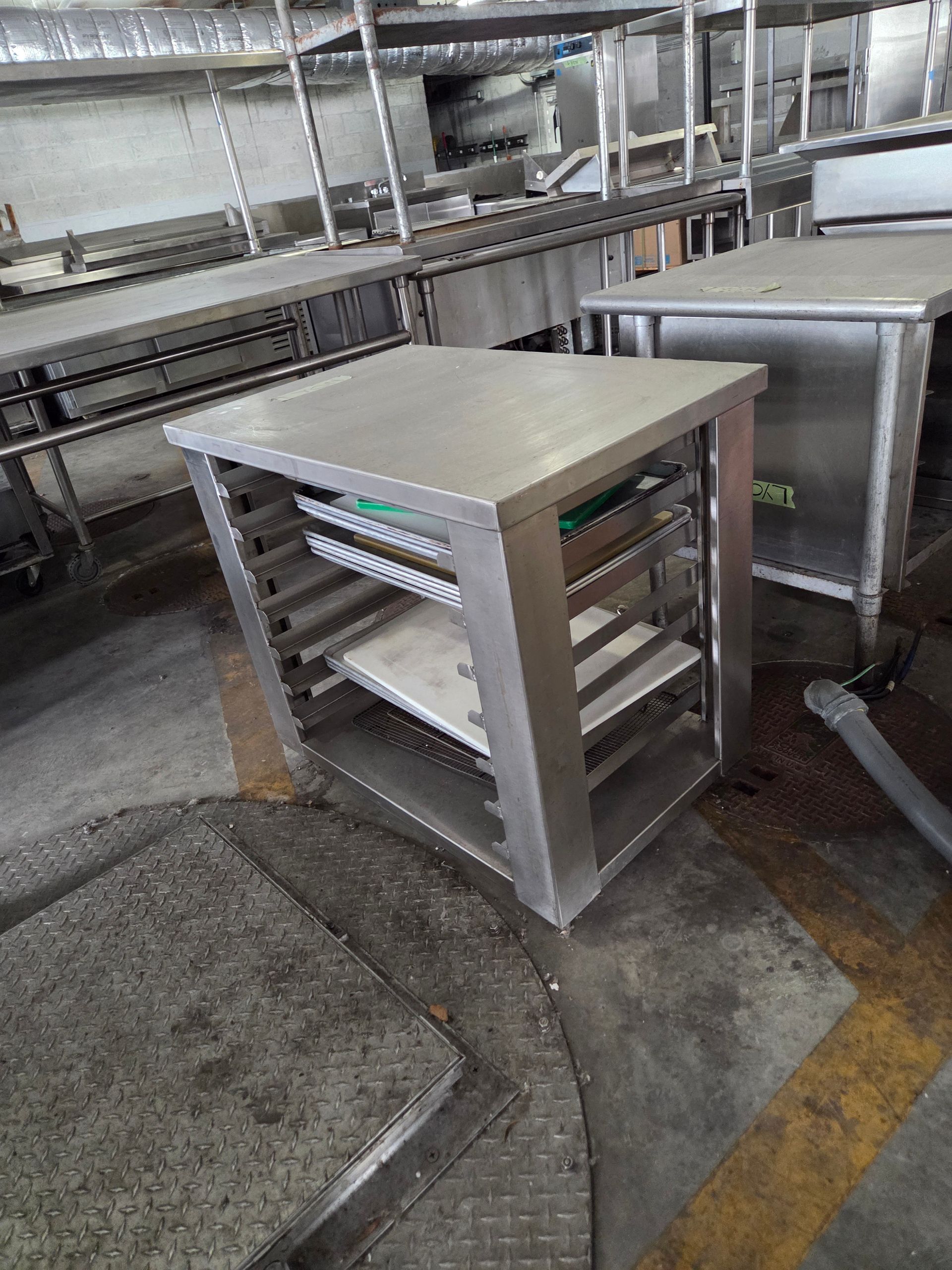 Stainless steel rolling shelf unit in a commercial kitchen.