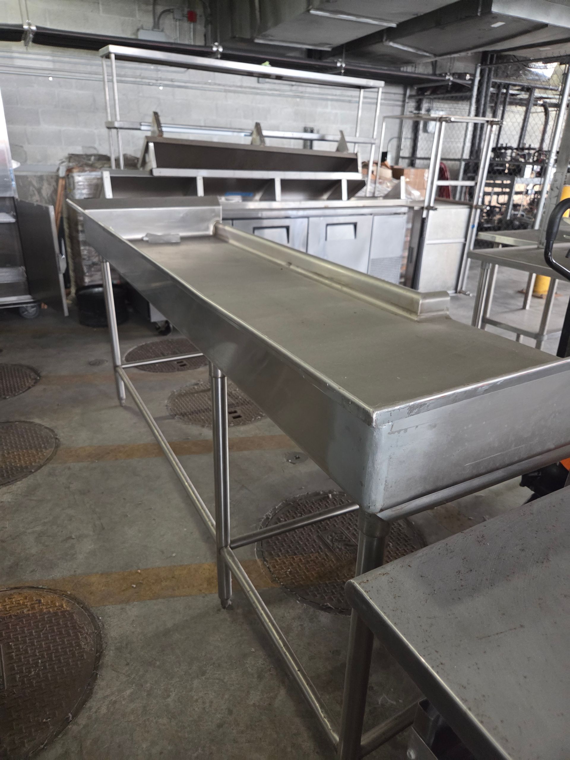 Stainless steel food preparation table in a commercial kitchen.